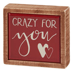 Wooden-framed decorative box sign with ’Crazy For You’ text and heart designs on a red background.